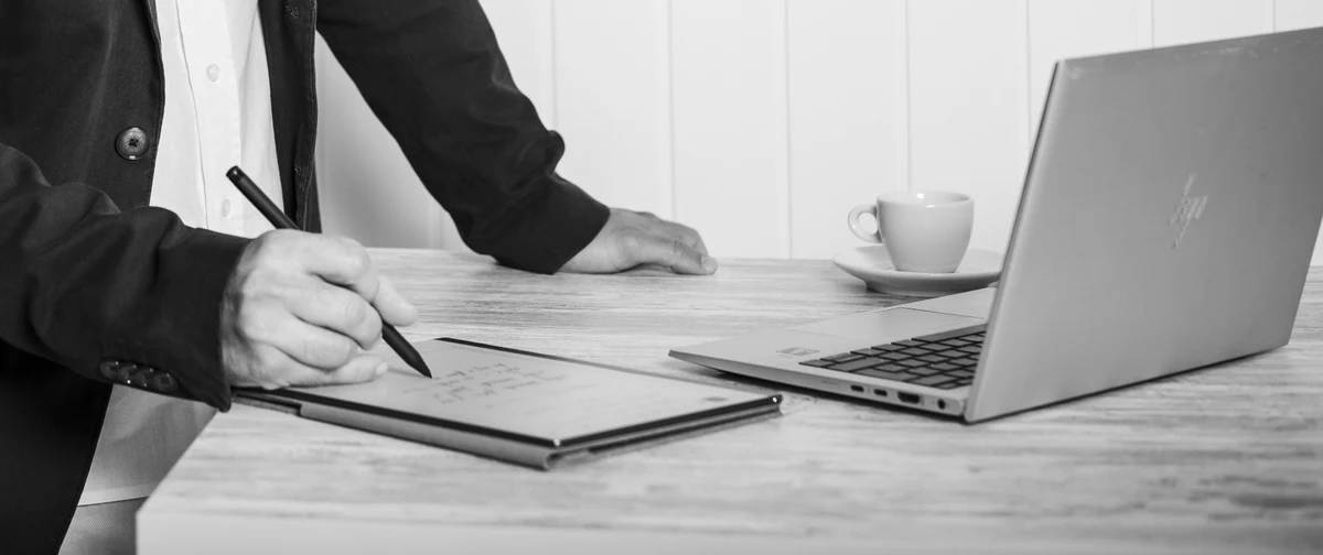 Working session — notebook, espresso, and laptop